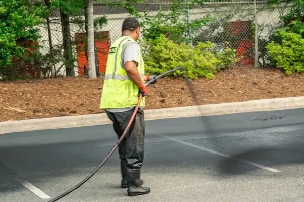 spraying first coat of sealant to the parking lot at point blankrange in matthew nc