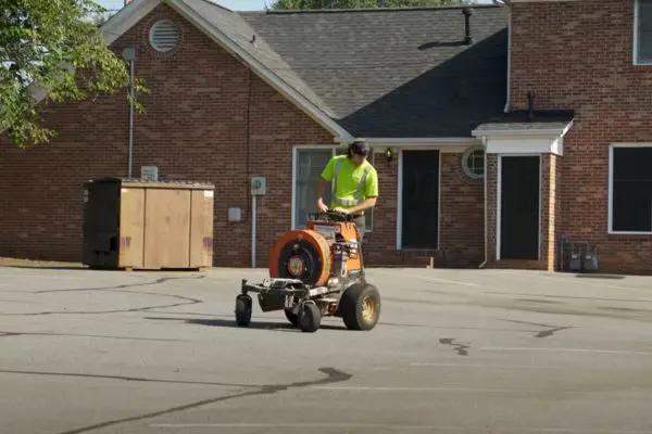 Man operating pavement crack sealing machine