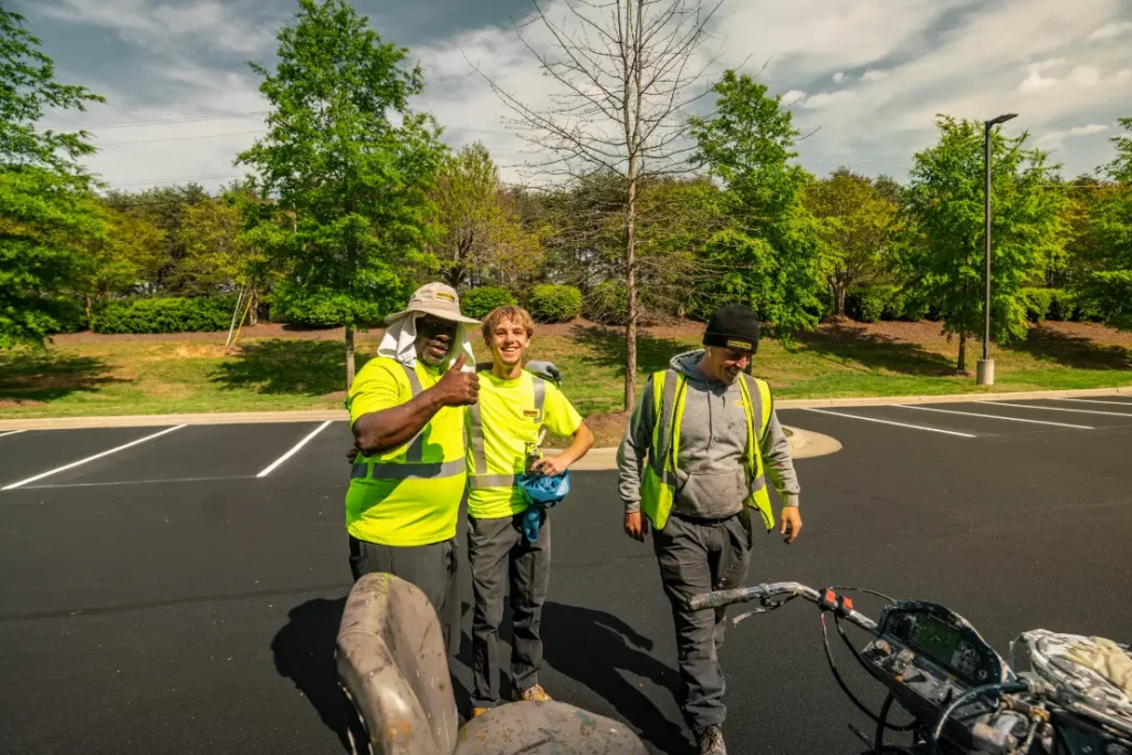 Three workers in reflective vests outdoors.