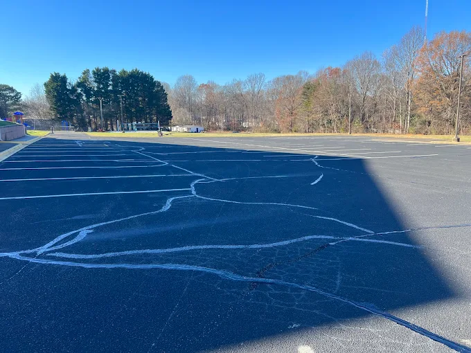 Cracked asphalt parking lot under blue sky